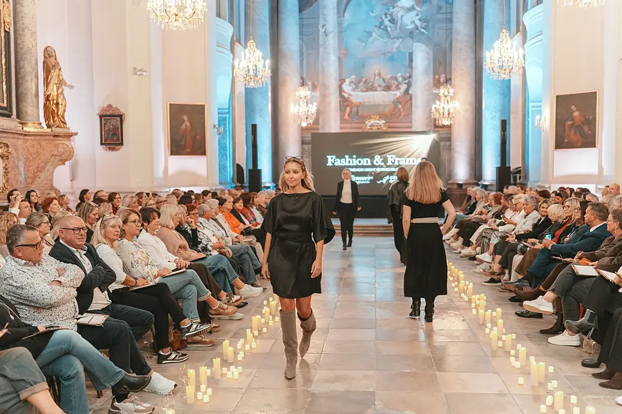 Auf dem kerzengesäumten Laufsteg: Model im schwarzen Kleid mit Puffärmeln